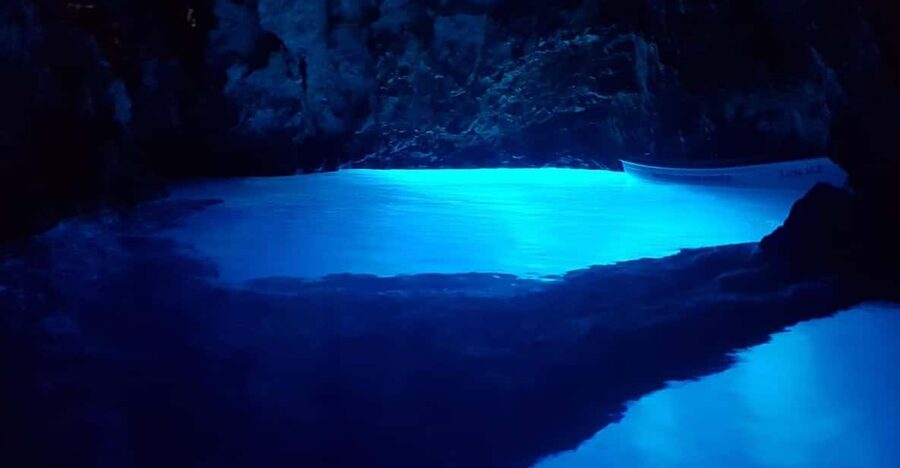 From Hvar: Blue cave group speedboat tour full day - Stiniva Cove: swimming toward a narrow opening